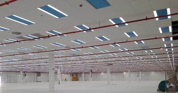 Armazém vazio com colunas e iluminação LED no teto.